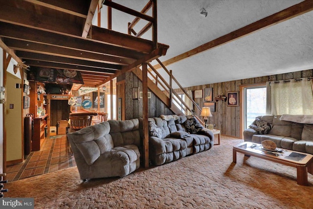 living room with beam ceiling, wooden walls, and a textured ceiling