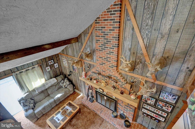 living room featuring wood walls and vaulted ceiling with beams