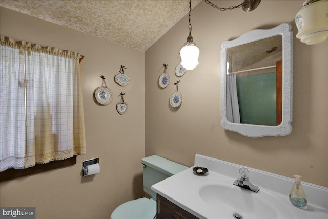 bathroom featuring vanity, a textured ceiling, and toilet