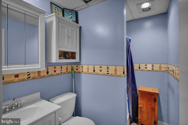 bathroom featuring vanity, a paneled ceiling, and toilet