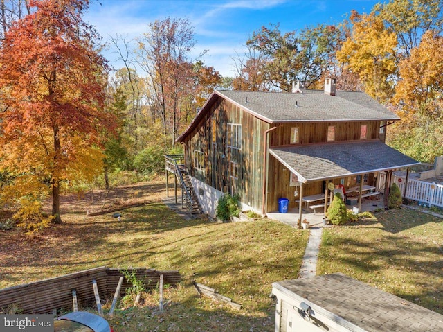 exterior space with covered porch and a yard