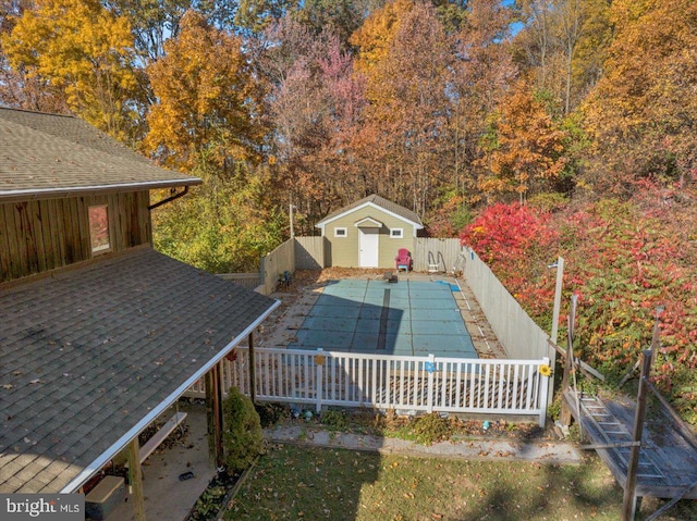 deck featuring a storage unit and a covered pool