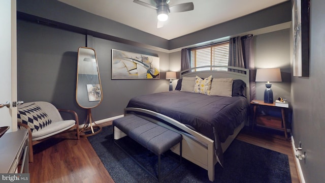 bedroom with dark hardwood / wood-style flooring and ceiling fan