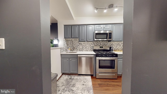 kitchen featuring gray cabinetry, decorative backsplash, and stainless steel appliances