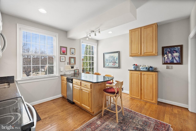 kitchen with light wood-type flooring, range, a breakfast bar, and kitchen peninsula