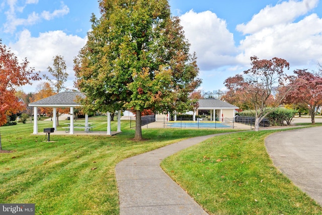 surrounding community featuring a gazebo, a lawn, and a swimming pool