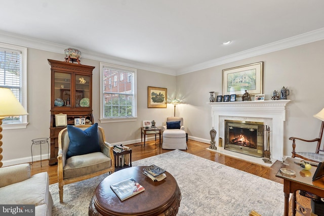 living area with hardwood / wood-style flooring, ornamental molding, and plenty of natural light