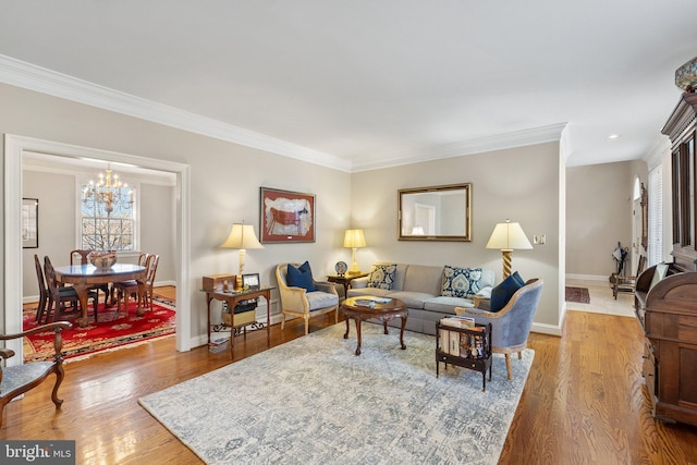 living room with an inviting chandelier, ornamental molding, and hardwood / wood-style flooring