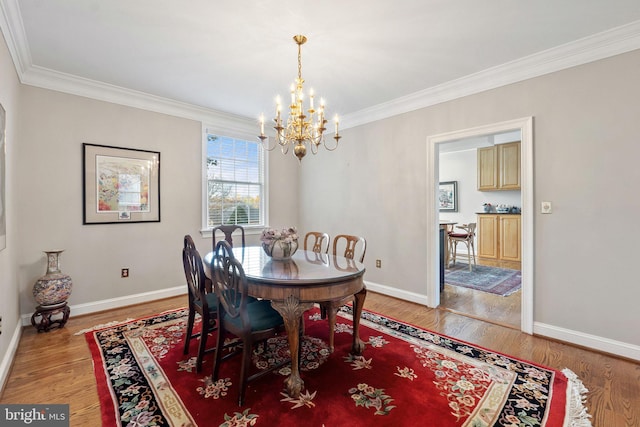 dining room featuring crown molding, a chandelier, and wood-type flooring