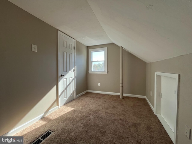 additional living space featuring lofted ceiling and carpet flooring