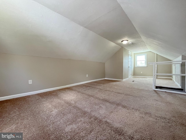 bonus room featuring lofted ceiling and carpet floors