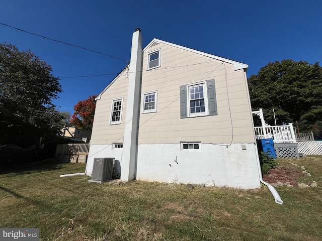 view of side of property with a yard and central AC unit