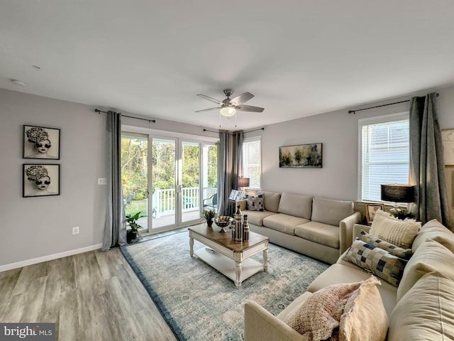 living room featuring light hardwood / wood-style flooring, ceiling fan, and a healthy amount of sunlight