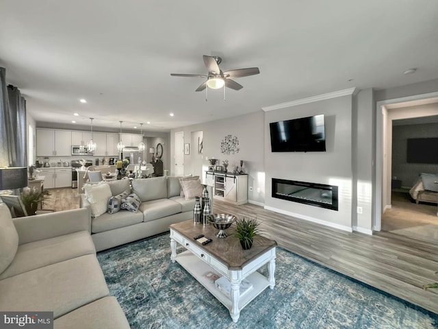 living room with ceiling fan with notable chandelier and dark wood-type flooring