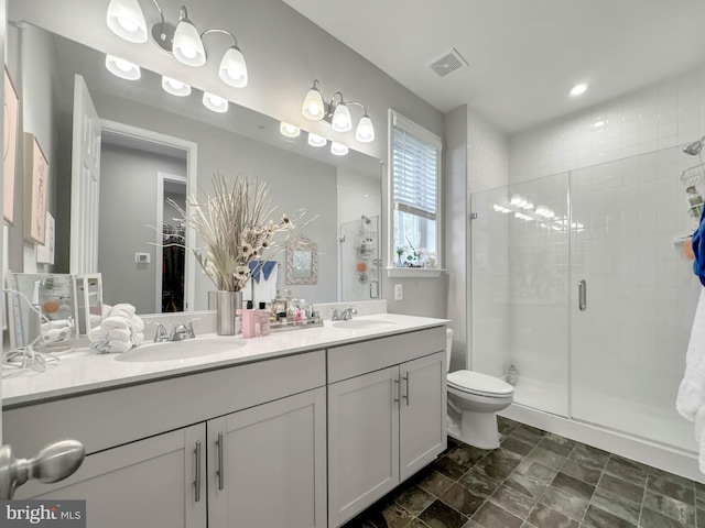 bathroom with toilet, vanity, and walk in shower