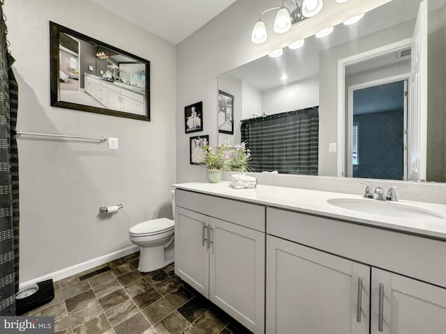 bathroom featuring curtained shower, vanity, and toilet