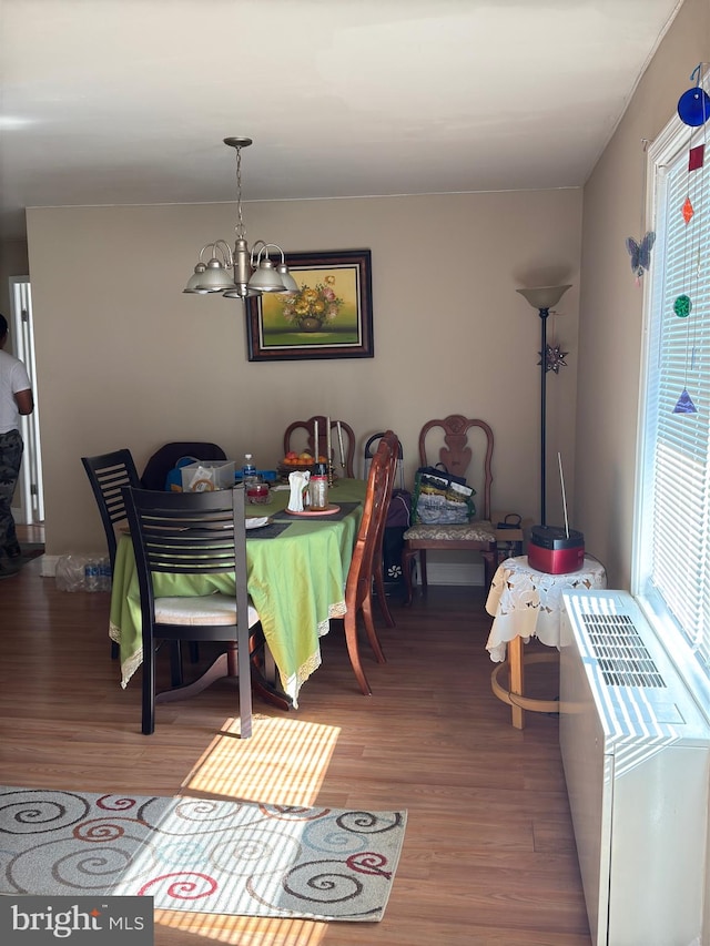 dining space with a notable chandelier, a healthy amount of sunlight, and hardwood / wood-style floors