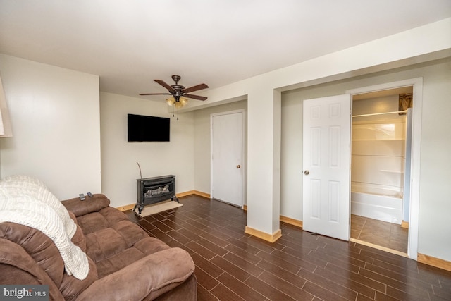 living room with a wood stove and ceiling fan