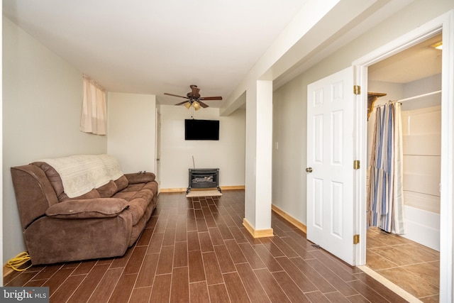 living room with a wood stove and ceiling fan