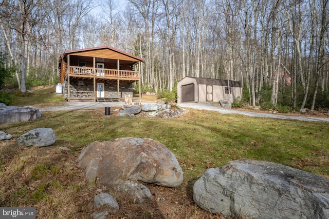 view of yard with a garage, a shed, and a wooden deck