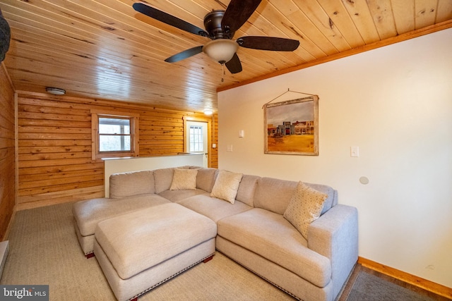 living room with wooden walls, wooden ceiling, ceiling fan, and crown molding