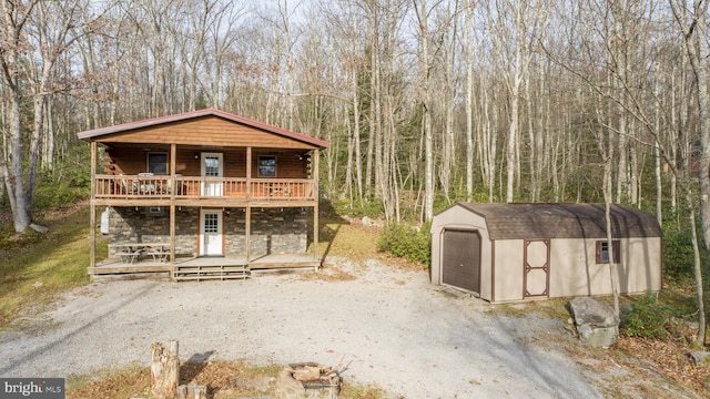 view of front of house with a garage, a wooden deck, and a storage unit