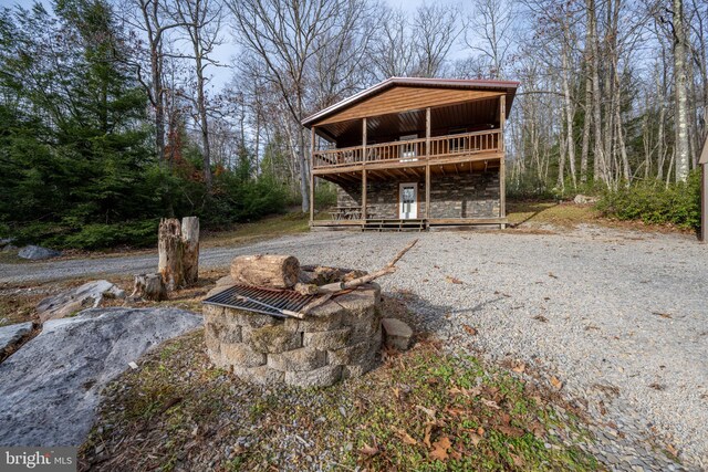 rear view of property featuring a wooden deck and an outdoor fire pit