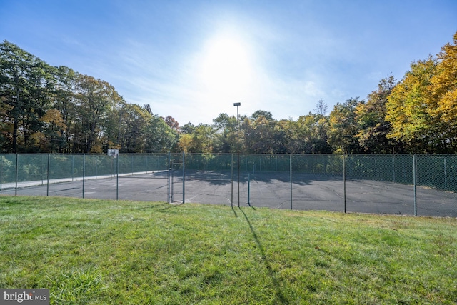 view of tennis court with a lawn