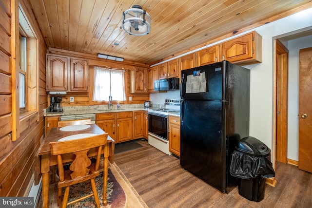 kitchen featuring dark hardwood / wood-style flooring, wood walls, black appliances, sink, and wooden ceiling