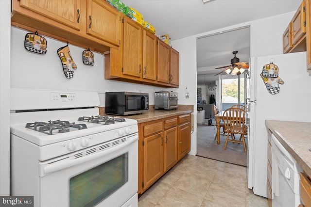 kitchen with white appliances, ceiling fan, and light colored carpet