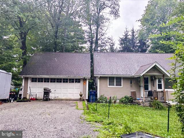 single story home with a detached garage and a front lawn