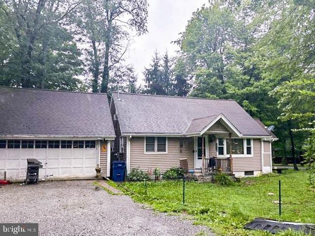 single story home featuring driveway, an attached garage, and a front yard