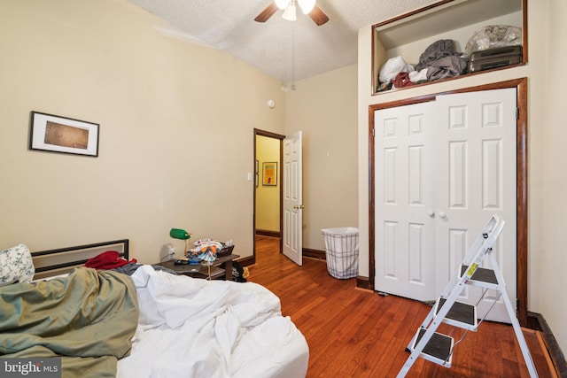 bedroom featuring ceiling fan, dark hardwood / wood-style floors, a textured ceiling, a closet, and vaulted ceiling