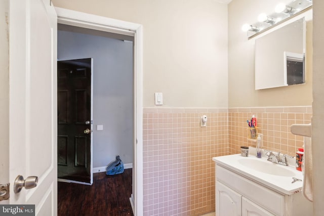 bathroom with tile walls, vanity, and hardwood / wood-style floors