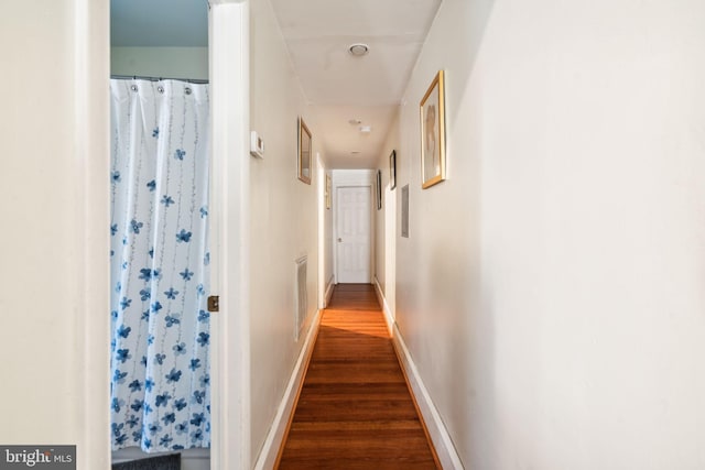 corridor with dark hardwood / wood-style flooring