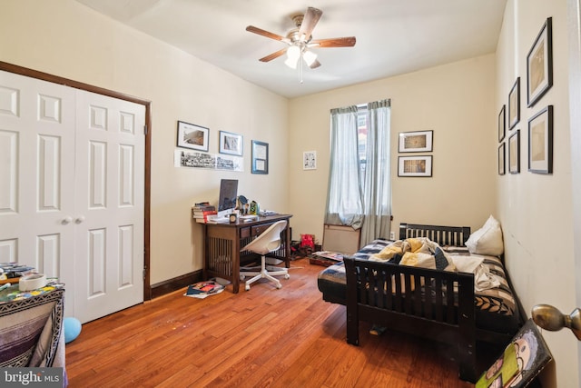 bedroom with wood-type flooring, ceiling fan, and a closet