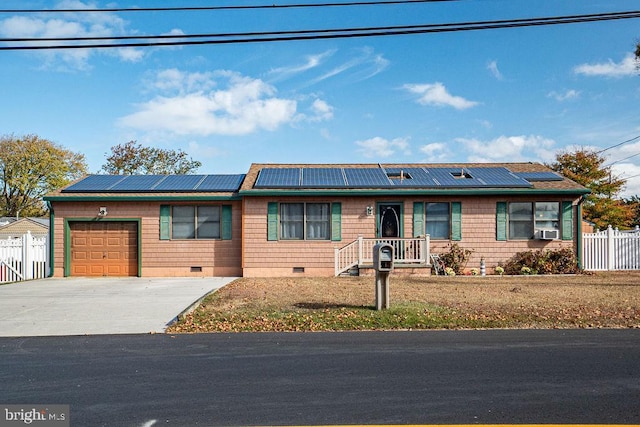 ranch-style house with solar panels, cooling unit, and a garage