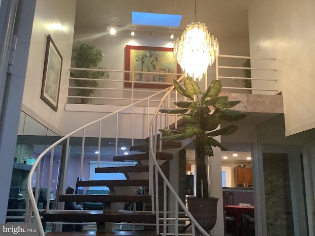 stairway with a towering ceiling and a notable chandelier