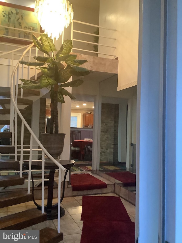 stairs featuring a chandelier and tile patterned flooring