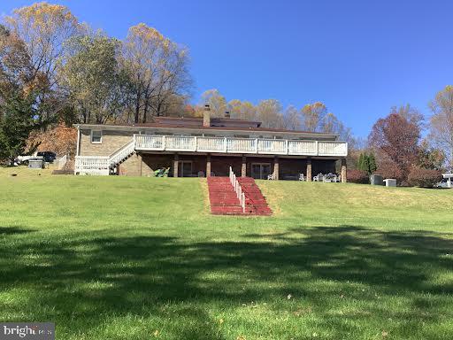 rear view of property featuring a lawn and a wooden deck