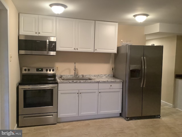 kitchen featuring appliances with stainless steel finishes, sink, and white cabinets