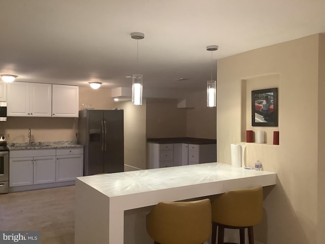 kitchen featuring pendant lighting, kitchen peninsula, black fridge with ice dispenser, and white cabinets