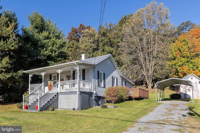 view of front of house featuring covered porch, a front yard, and a carport