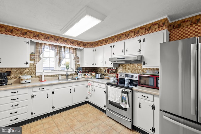 kitchen with stainless steel appliances, sink, white cabinetry, a textured ceiling, and tasteful backsplash