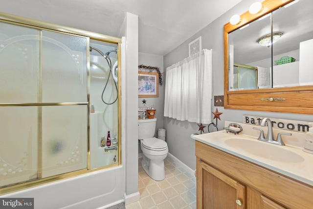 full bathroom featuring vanity, bath / shower combo with glass door, and toilet