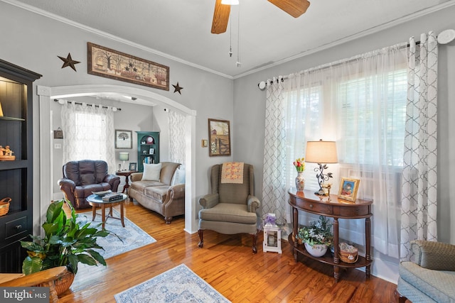 living area with ceiling fan, hardwood / wood-style flooring, and ornamental molding