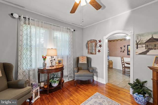 living area featuring crown molding, hardwood / wood-style floors, and ceiling fan