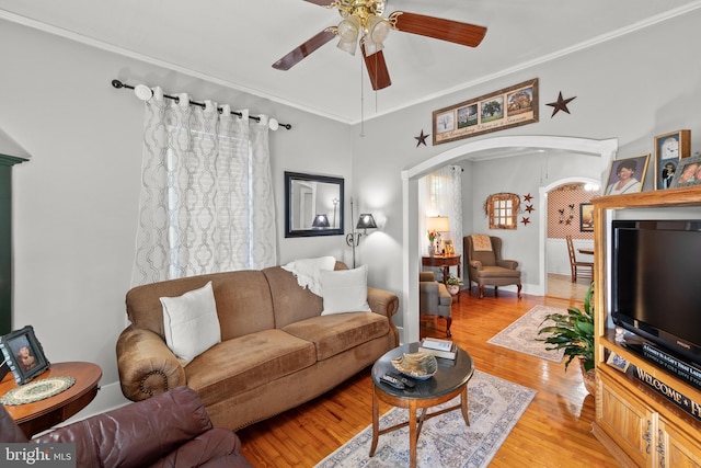 living room featuring light hardwood / wood-style floors, crown molding, and ceiling fan