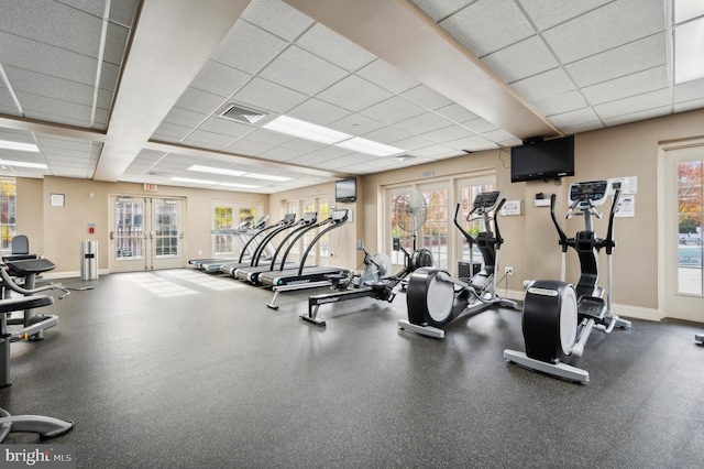 workout area featuring a drop ceiling, french doors, and plenty of natural light