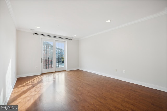 empty room featuring french doors, hardwood / wood-style flooring, and crown molding